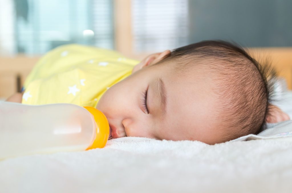 Asian baby sleeping and drinking milk
